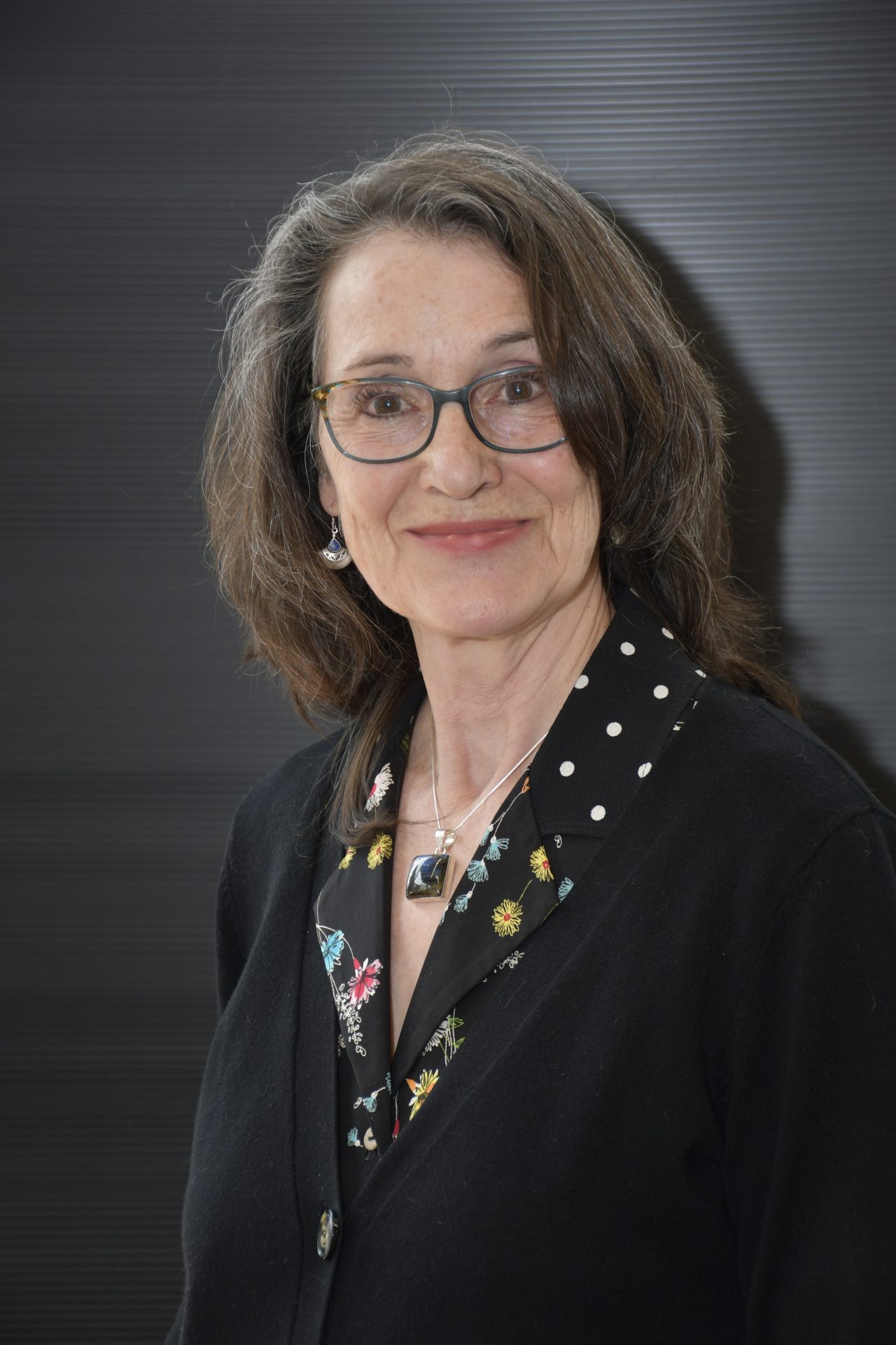 Second portrait public de Christine Bouchard, cadrage vertical, veste noire et pendentif de pierre.
